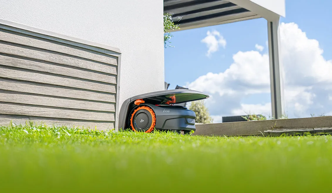 Segway Navimow i1 series in the charging station at the edge of the lawn