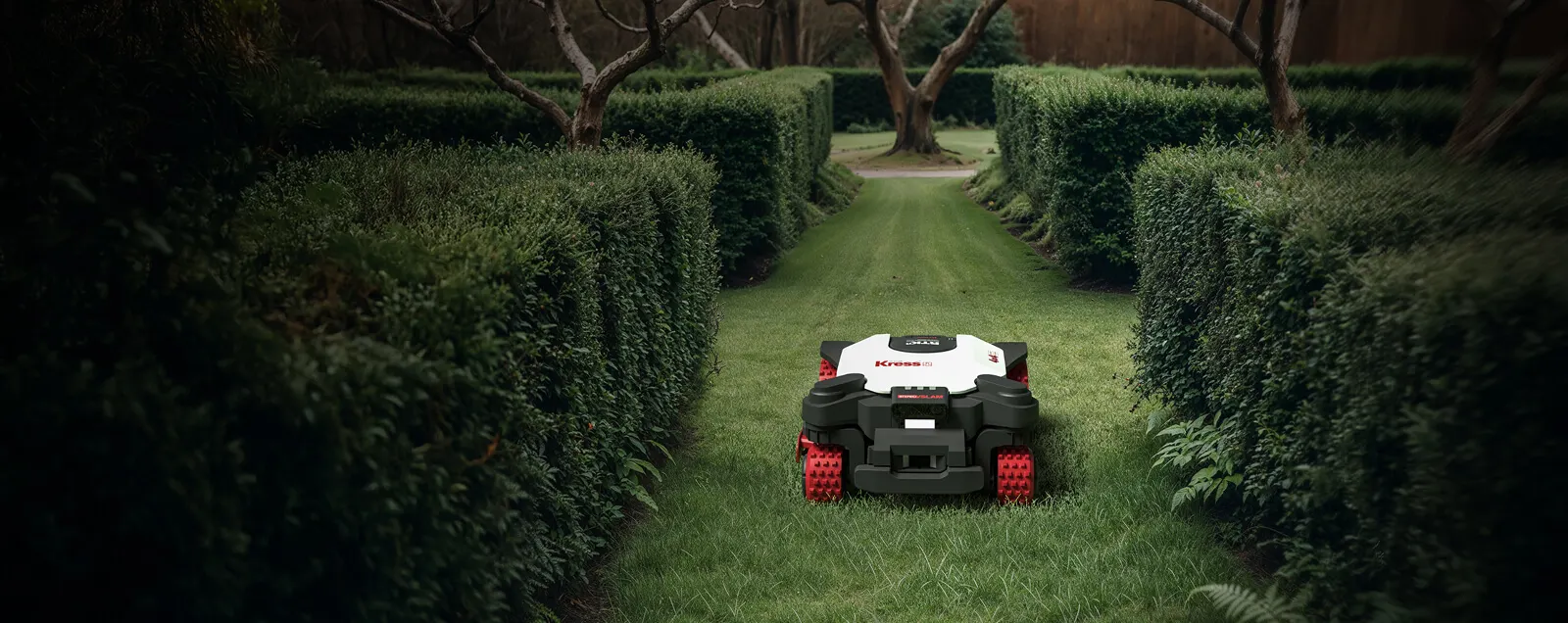Kress EyePilot robotic mower drives through a narrow hedge passage in the garden
