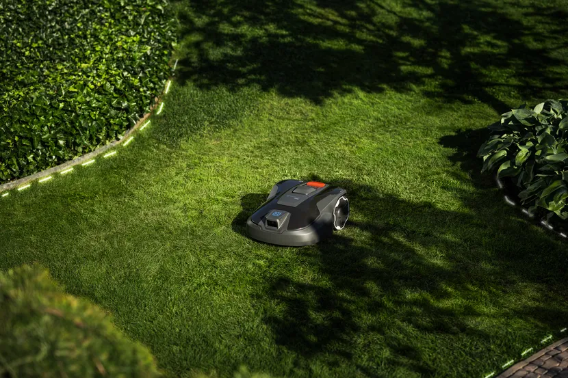 Husqvarna Automower Aspire R6V kosi w ogrodzie z zacienionymi obszarami